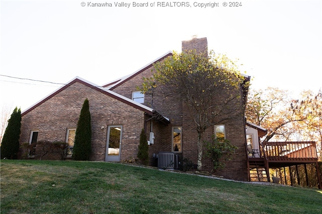 view of home's exterior featuring a deck, central AC unit, and a lawn