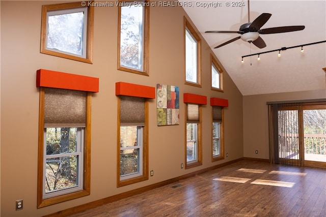 empty room featuring hardwood / wood-style floors, high vaulted ceiling, ceiling fan, and a healthy amount of sunlight