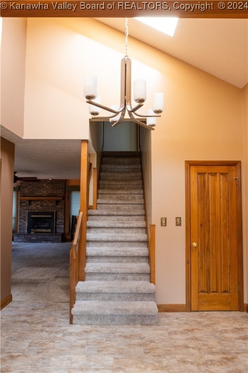 stairs featuring a fireplace and high vaulted ceiling