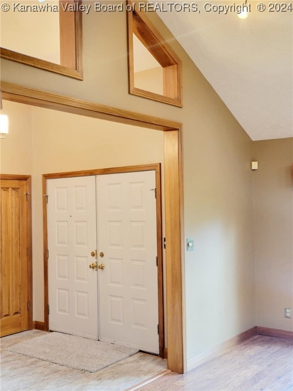 entrance foyer with hardwood / wood-style floors and lofted ceiling