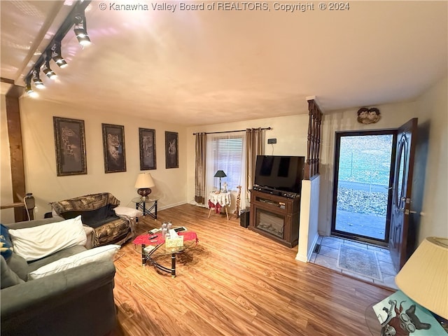 living room featuring wood-type flooring, track lighting, and plenty of natural light