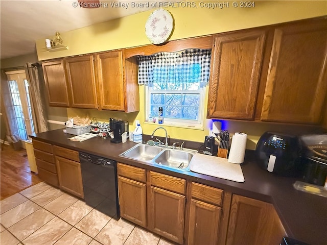 kitchen with sink, black dishwasher, and light hardwood / wood-style floors