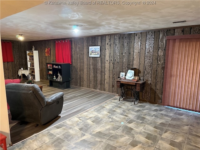 unfurnished living room with wood walls