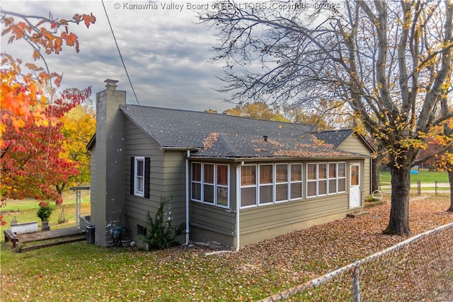 rear view of property featuring a sunroom