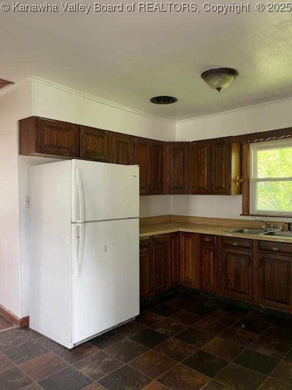 kitchen with white refrigerator, ornamental molding, and sink