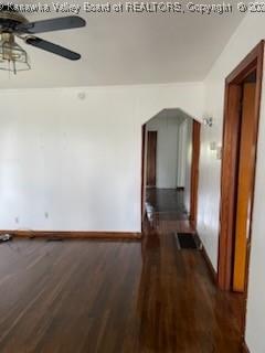 empty room with dark hardwood / wood-style floors and ceiling fan