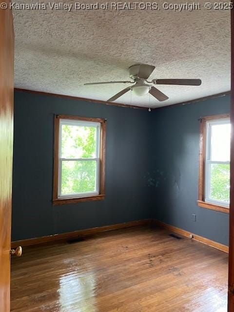 spare room with hardwood / wood-style flooring, ceiling fan, and a textured ceiling