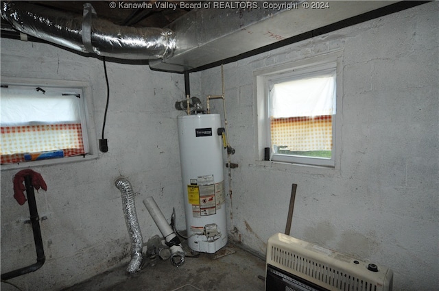 utility room featuring gas water heater and heating unit