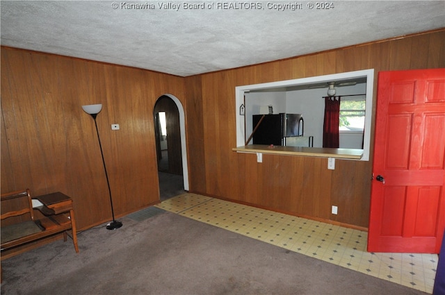 interior space featuring wood walls and a textured ceiling