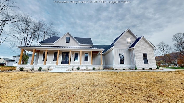 modern farmhouse with a porch and a front yard