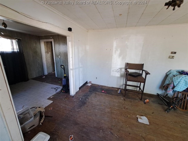 interior space with dark hardwood / wood-style flooring, wood walls, and crown molding