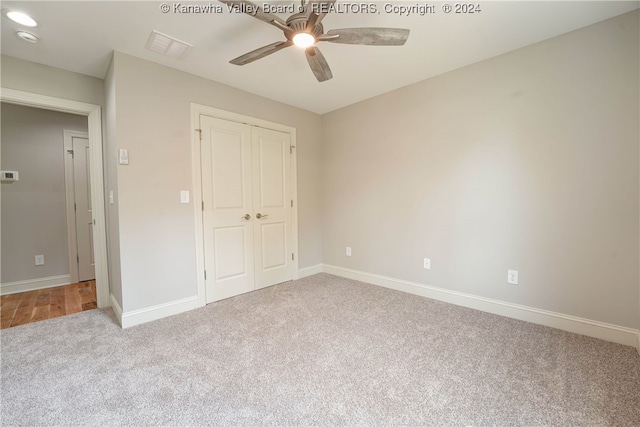 unfurnished bedroom featuring ceiling fan, light carpet, and a closet