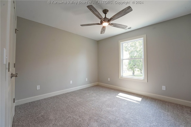 carpeted spare room with ceiling fan