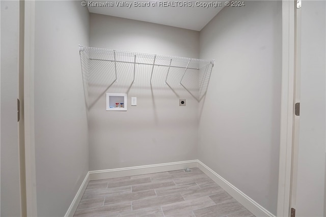 laundry room featuring hookup for an electric dryer, light hardwood / wood-style flooring, and washer hookup