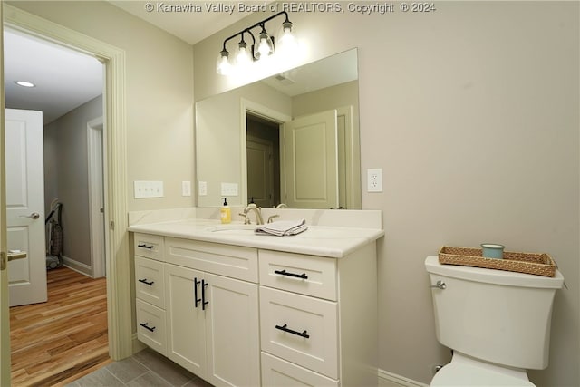 bathroom featuring hardwood / wood-style floors, vanity, and toilet