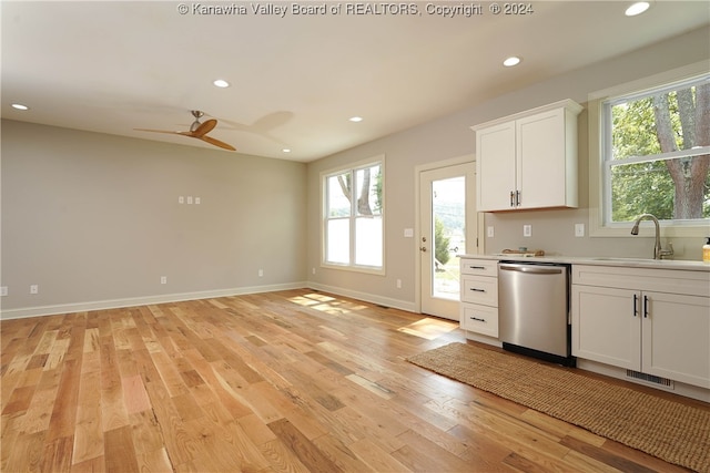 kitchen with dishwasher, plenty of natural light, sink, and white cabinets