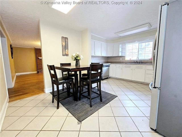 dining room featuring light hardwood / wood-style flooring, a textured ceiling, and sink