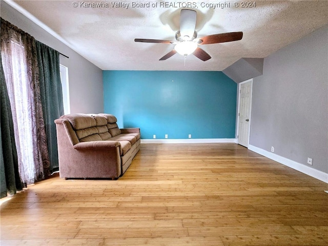 unfurnished room with ceiling fan, a textured ceiling, light hardwood / wood-style flooring, and lofted ceiling