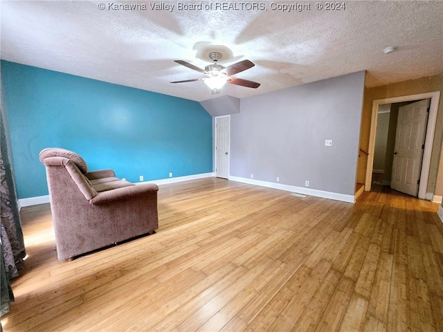 interior space with ceiling fan, a textured ceiling, and light hardwood / wood-style floors