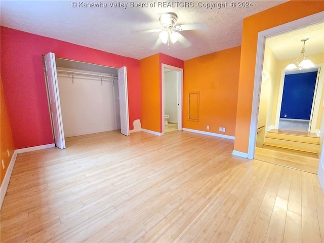 unfurnished bedroom with a textured ceiling, light wood-type flooring, ceiling fan, and connected bathroom