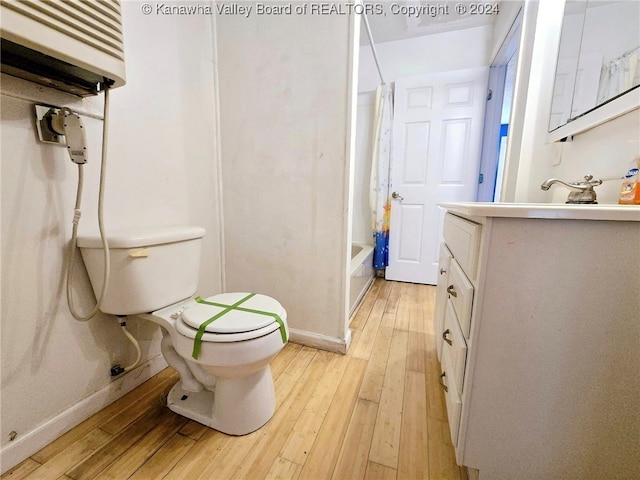 full bathroom featuring vanity, wood-type flooring, toilet, and shower / bathtub combination with curtain