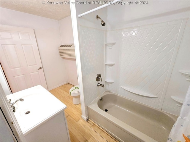 full bathroom with wood-type flooring, toilet, a textured ceiling, vanity, and shower / bathtub combination with curtain