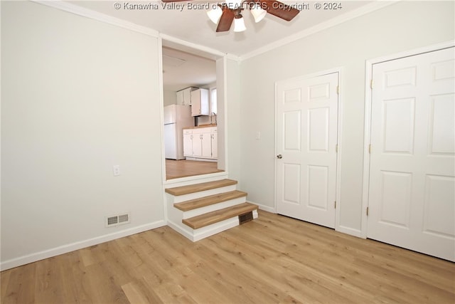 interior space with light hardwood / wood-style flooring, ceiling fan, crown molding, and white fridge