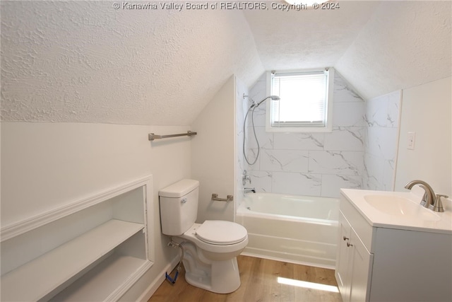 full bathroom with wood-type flooring, lofted ceiling, tiled shower / bath, a textured ceiling, and vanity