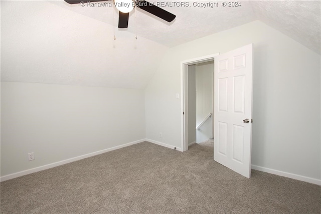 bonus room with carpet, lofted ceiling, a textured ceiling, and ceiling fan