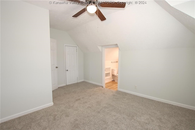 bonus room with lofted ceiling, a textured ceiling, light colored carpet, and ceiling fan