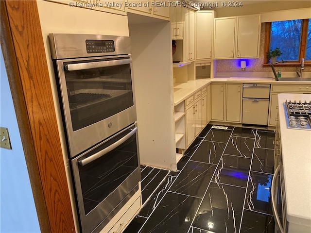 kitchen featuring backsplash, sink, and appliances with stainless steel finishes