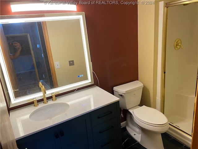 bathroom featuring tile patterned flooring, vanity, an enclosed shower, and toilet