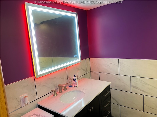 bathroom with vanity and tile walls