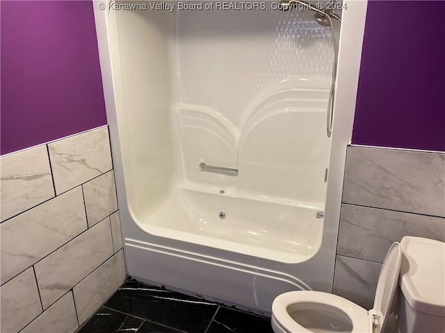 bathroom with  shower combination, toilet, and tile walls