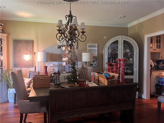 dining space with hardwood / wood-style floors, crown molding, and a chandelier