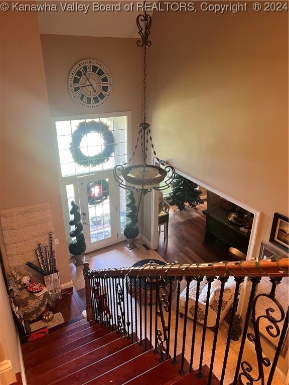 staircase featuring hardwood / wood-style floors, a towering ceiling, and a wealth of natural light