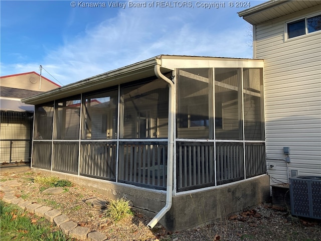 view of property exterior featuring a sunroom and central air condition unit