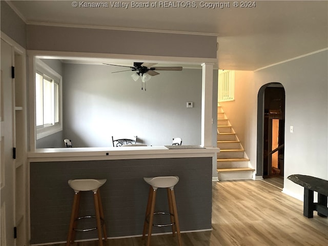 bar with hardwood / wood-style floors, ceiling fan, and crown molding