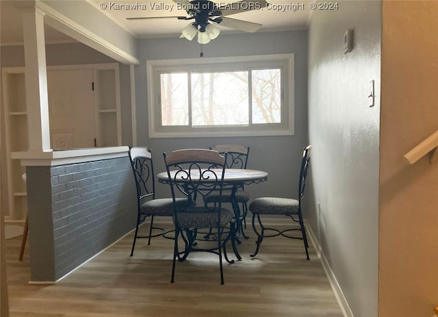 dining space featuring wood-type flooring and ceiling fan