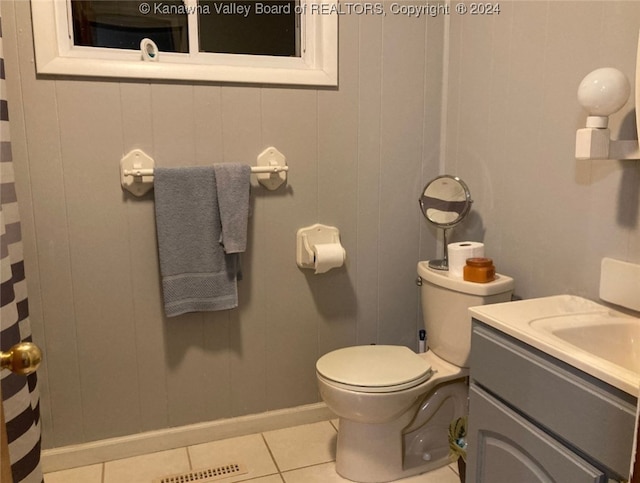 bathroom with tile patterned flooring, vanity, wood walls, and toilet