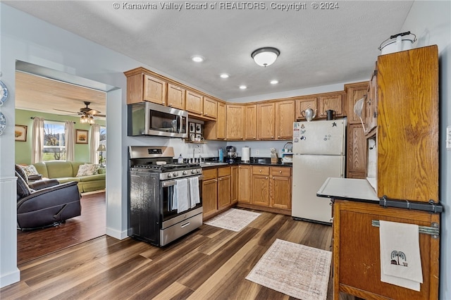 kitchen featuring dark wood-type flooring, sink, ceiling fan, a textured ceiling, and appliances with stainless steel finishes