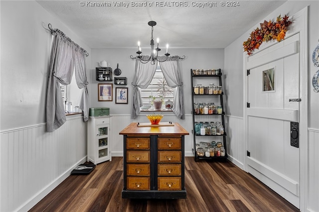 dining space featuring a textured ceiling, dark hardwood / wood-style flooring, and an inviting chandelier