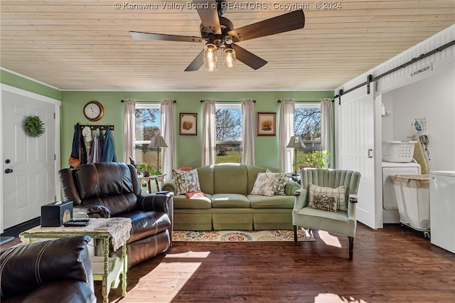 living room with dark hardwood / wood-style floors, a barn door, ceiling fan, wood ceiling, and washer / clothes dryer