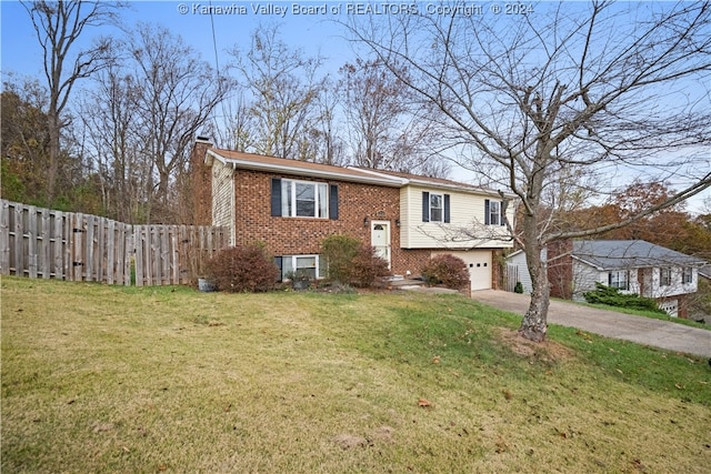 raised ranch featuring a front yard and a garage