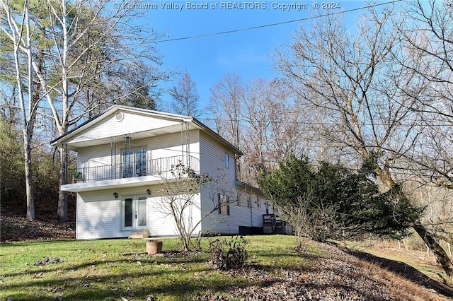 back of house featuring a yard and a balcony