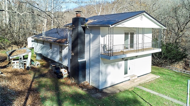 view of property exterior featuring a lawn and a balcony