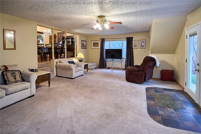 carpeted living room with ceiling fan with notable chandelier, a textured ceiling, and a wealth of natural light