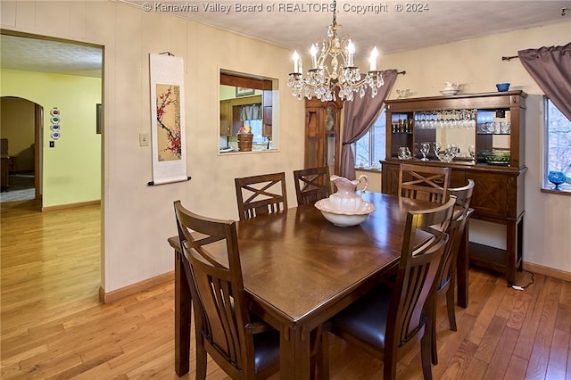 dining area featuring hardwood / wood-style flooring, plenty of natural light, and an inviting chandelier