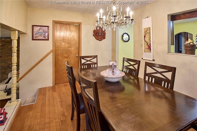 dining area with hardwood / wood-style flooring and a notable chandelier