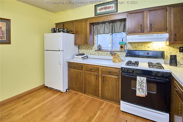 kitchen with white appliances and light wood-type flooring